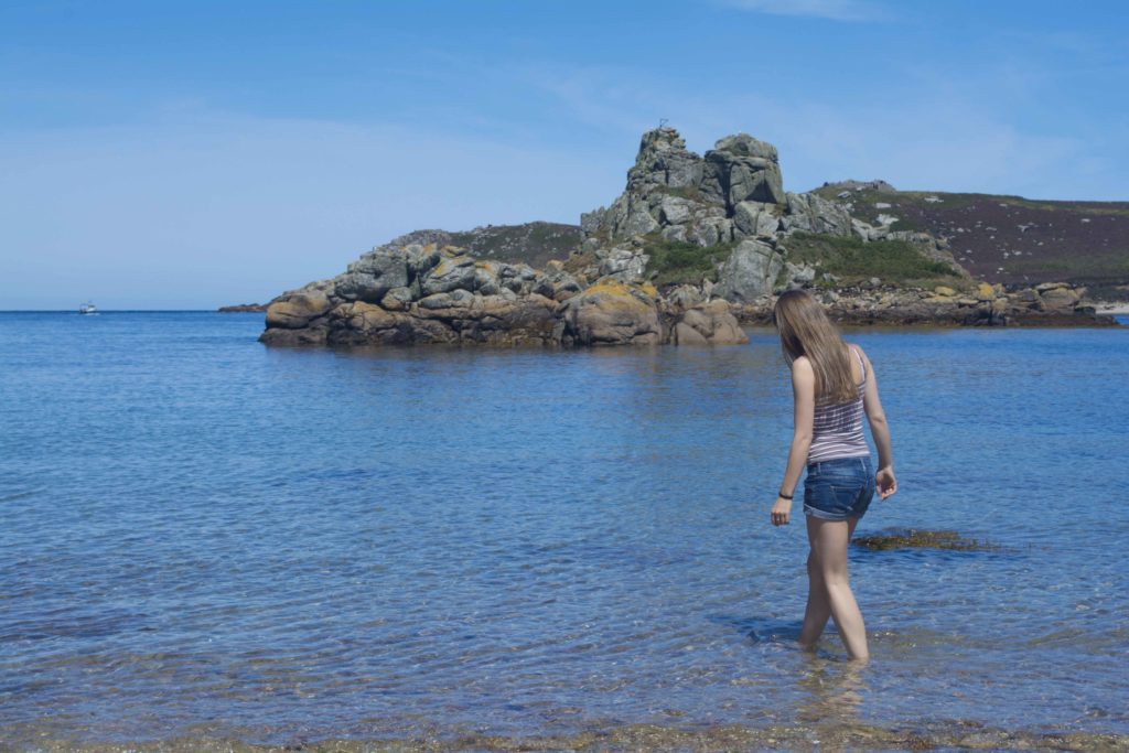 Young woman paddling in the sea off Bryher Isles of Scilly